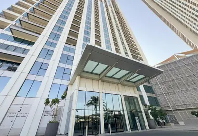 a tall building with glass windows and palm trees at Stunning 2 Bedroom Apartment Downtown Views 2 - Tower 3 Downtown Dubai in Dubai