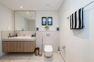 a bathroom with a sink and a toilet and a mirror at Exclusive front row seats to Burj Khalifa fireworks from penthouse level, downtown Dubai in Dubai