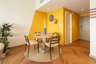 a dining room with yellow walls and a table and chairs at Exclusive front row seats to Burj Khalifa fireworks from penthouse level, downtown Dubai in Dubai