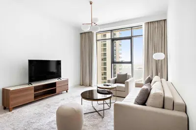 a living room with a couch and a tv at Silkhaus Palm View in Marina Vista Private Beach in Dubai