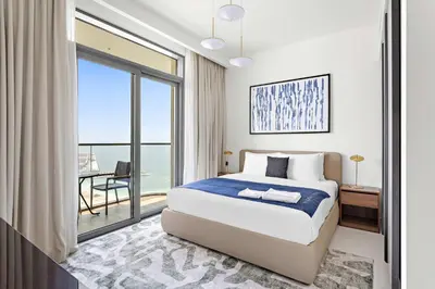 a bedroom with a bed and a large window at Silkhaus Palm View in Marina Vista Private Beach in Dubai