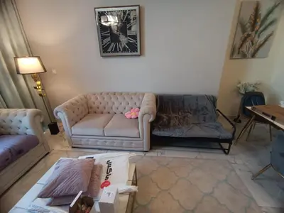 a living room with a couch and a table at Al Quoz 2 Bed Budget Apartment in Dubai