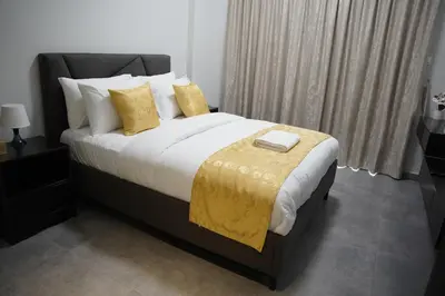 a bedroom with a large bed with yellow pillows at Ista Vacation Homes Rental LLC KARAMA in Dubai