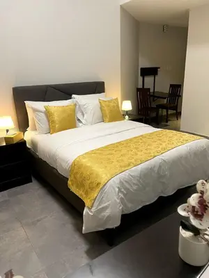 a bedroom with a large bed with yellow and white pillows at Ista Vacation Homes Rental LLC KARAMA in Dubai