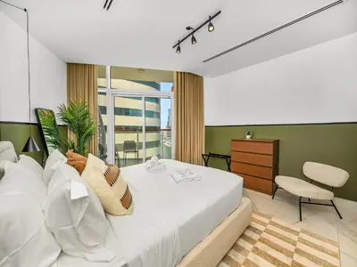 a bedroom with a white bed and a green wall at Sukoon's Waterfront Two-Bedroom in Dubai