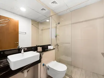 a bathroom with a toilet and a sink and a shower at Sukoon's Waterfront Two-Bedroom in Dubai