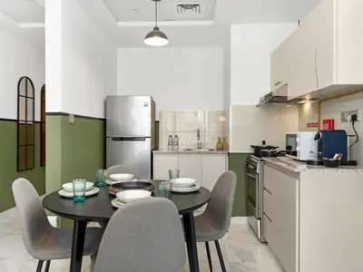 a kitchen with a table and chairs in a kitchen at Sukoon's Waterfront Two-Bedroom in Dubai