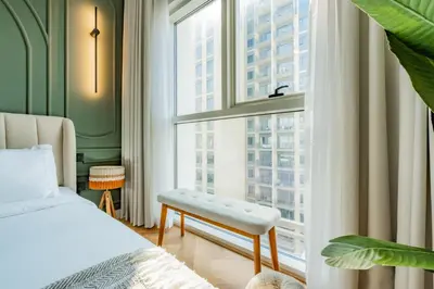a bedroom with a bed and a large window at Elite Escapes - Socio Stylish 1 BHK Getaway in Dubai