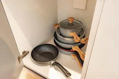 a shelf with a pan and a stack of dishes at Elite Escapes - Socio Stylish 1 BHK Getaway in Dubai