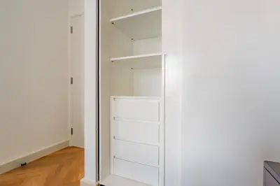 a closet with white shelves and a mirror at Elite Escapes - Socio Stylish 1 BHK Getaway in Dubai