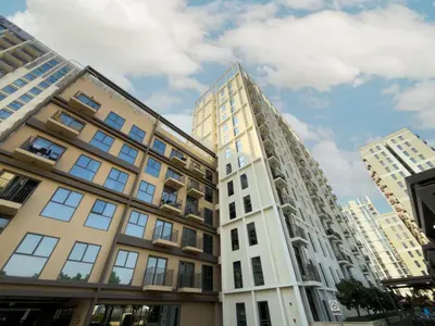 a tall white building next to two tall buildings at Elite Escapes - Socio Stylish 1 BHK Getaway in Dubai