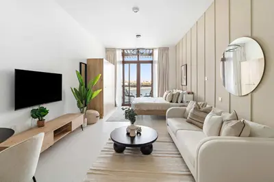 a living room with a couch and a tv at Silkhaus Beach Accessible Studio Palm View in Dubai