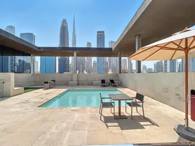 a patio with a table and chairs next to a pool at 2BR plus M with Huge Balcony City Walk Building 22 in Dubai