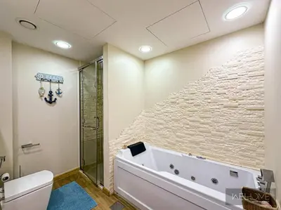 a bathroom with a bath tub and a stone wall at WelHome - Stylish Breathtaking 2BR Apartment in Marina in Dubai