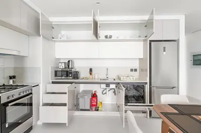 a kitchen with white cabinets and a refrigerator at Silkhaus 1BDR with Private Beach Skyline Views in Dubai