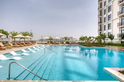 a swimming pool with lounge chairs and a hotel at Blueground Dubai Hills Estate balcony elev DXB-1120 in Dubai