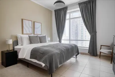 a bedroom with a large bed and a large window at Blueground Burj Views A sauna game room DXB-1386 in Dubai