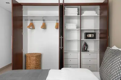 a bedroom with a closet with white shelves and a bed at Blueground Burj Views A sauna game room DXB-1386 in Dubai