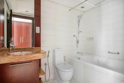 a bathroom with a tub and a toilet and a sink at Blueground Burj Views A sauna game room DXB-1386 in Dubai