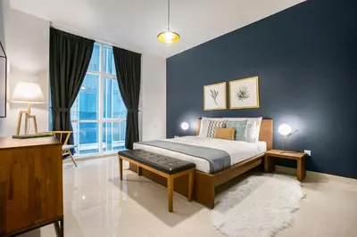 a bedroom with a bed and a blue wall at Blueground Sheikh Zayed Rd pool gym DXB-545 in Dubai