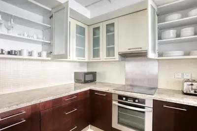 a kitchen with wooden cabinets and a stove top oven at Blueground Boulevard Central pool gym DXB-1179 in Dubai