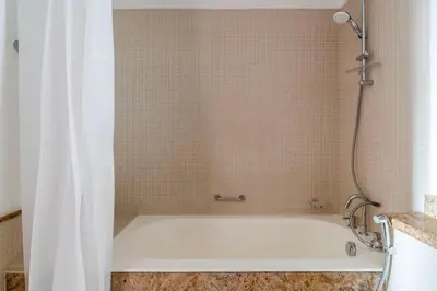 a bath tub with a shower curtain in a bathroom at Blueground South Ridge Tower 1 city view pool DXB-1409 in Dubai