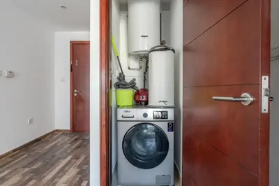 a laundry room with a washing machine and a door at Blueground South Ridge Tower 1 city view pool DXB-1409 in Dubai