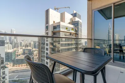 a table and chairs on the balcony of a building at Blueground South Ridge Tower 1 city view pool DXB-1409 in Dubai