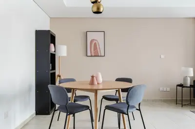 a dining room with a wooden table and blue chairs at Blueground JLT lake view roof pool gym DXB-1546 in Dubai