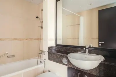 a bathroom with a sink and a toilet and a mirror at Blueground JLT lake view roof pool gym DXB-1546 in Dubai