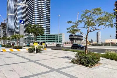 a parking lot with a palm tree in a city at Blueground JLT lake view roof pool gym DXB-1546 in Dubai