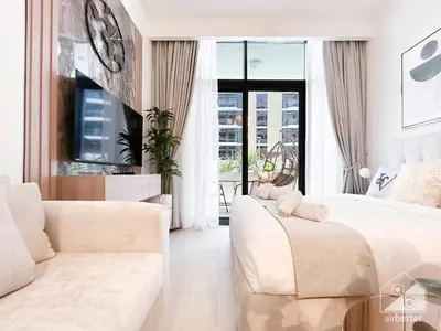 a living room with white furniture and a large window at Charming Studio with Balcony in Azizi Riviera in Dubai