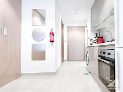 a white kitchen with a stove and a refrigerator at Charming Studio with Balcony in Azizi Riviera in Dubai