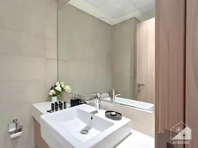 a white bathroom with a sink and a mirror at Charming Studio with Balcony in Azizi Riviera in Dubai