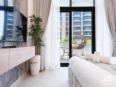 a bedroom with a bed and a large window at Charming Studio with Balcony in Azizi Riviera in Dubai