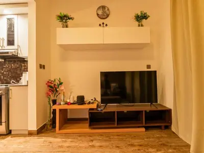 a living room with a television and a table at Al Barsha South Fourth in Dubai
