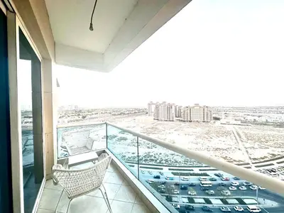 a balcony with a chair and a view of a parking lot at Amazing Studio Apartment in The Crescent A Tower IMPZ in Dubai