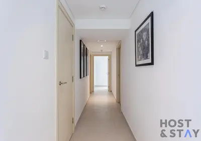 a hallway with white walls and a picture on the wall at Elegant Beachfront Living at Al Bateen in Dubai