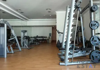a gym with a lot of treadmills and machines at Elegant Beachfront Living at Al Bateen in Dubai