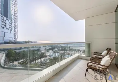 a balcony with two chairs and a view of the ocean at Elegant Beachfront Living at Al Bateen in Dubai