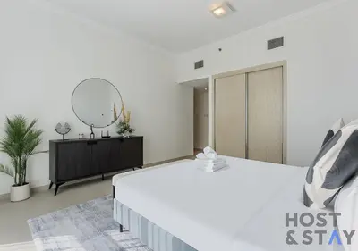a bedroom with a bed and a dresser and a mirror at Elegant Beachfront Living at Al Bateen in Dubai