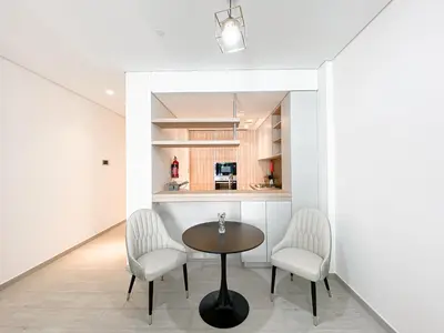 a dining room with a table and two chairs at Wilton Terrace Charm- Stylish 1-Bedroom in MBR City With a Pool View in Dubai