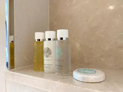 three bottles ofodorizers sitting on a shelf in a bathroom at Wilton Terrace Charm- Stylish 1-Bedroom in MBR City With a Pool View in Dubai
