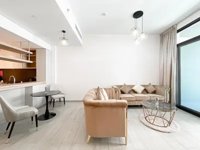 a living room with a couch and a table at Wilton Terrace Charm- Stylish 1-Bedroom in MBR City With a Pool View in Dubai