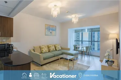 a living room with a couch and a table at Elite Residence - Cosy One Bedroom Apartment in Dubai