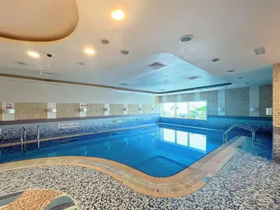 a large swimming pool in a building at Elite Residence - Cosy One Bedroom Apartment in Dubai