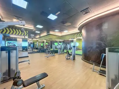 a fitness room with a gym with a large tv at Elite Residence - Cosy One Bedroom Apartment in Dubai
