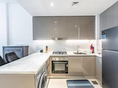 a kitchen with a stove and a dishwasher at Luxury Meydan Escape Condo with City Views in Dubai