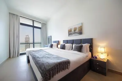 a bedroom with a large bed with a large window at Burj Vista Downtown Near To Dubai Mall - 2BHK in Dubai