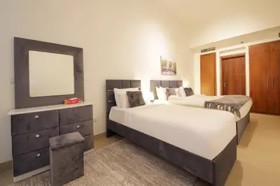 a bedroom with two beds and a mirror and a dresser at Burj Vista Downtown Near To Dubai Mall - 2BHK in Dubai